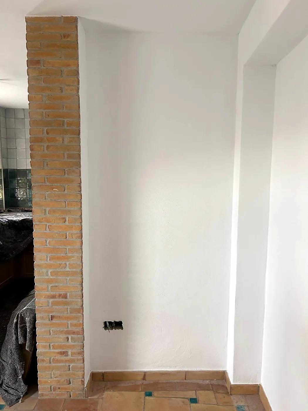 Witte muur naast een pilaar van schoon metselwerk